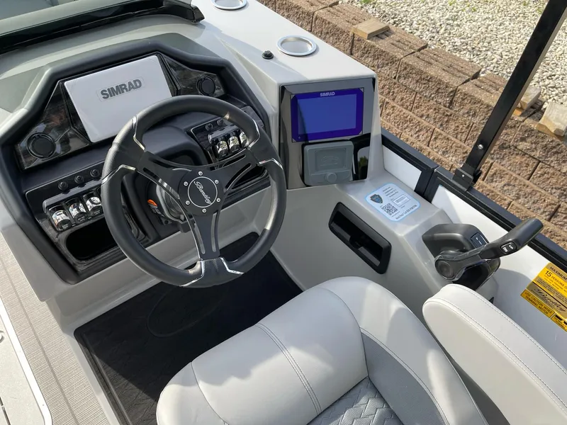 Slide: The Image of 2025 Bentley Pontoons Elite 223 Swingback dashboard with steering wheel and control panel. - 16
