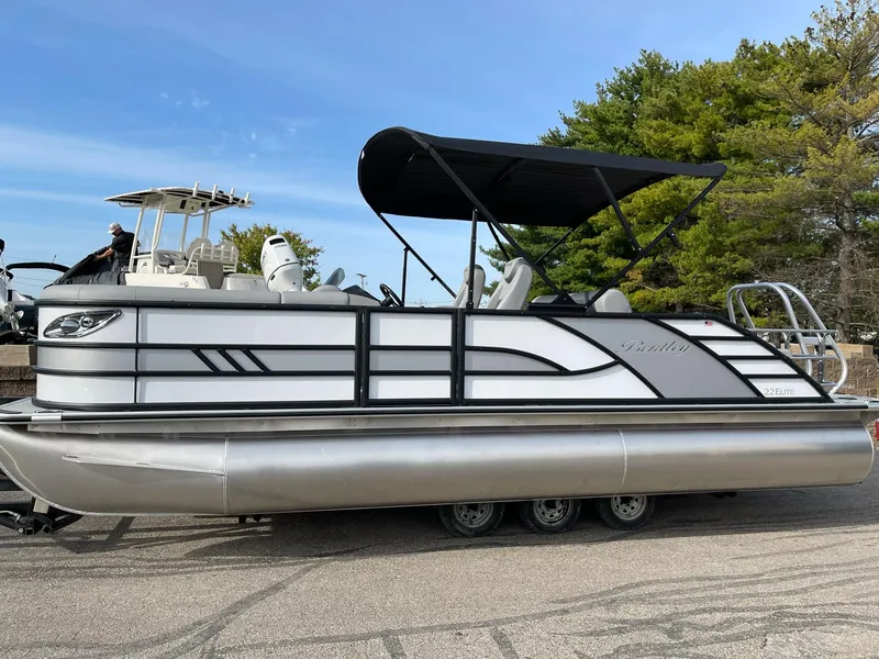 Slide: The Image of 2025 Bentley Pontoons Elite 223 Swingback with canopy, parked on a trailer. - 3