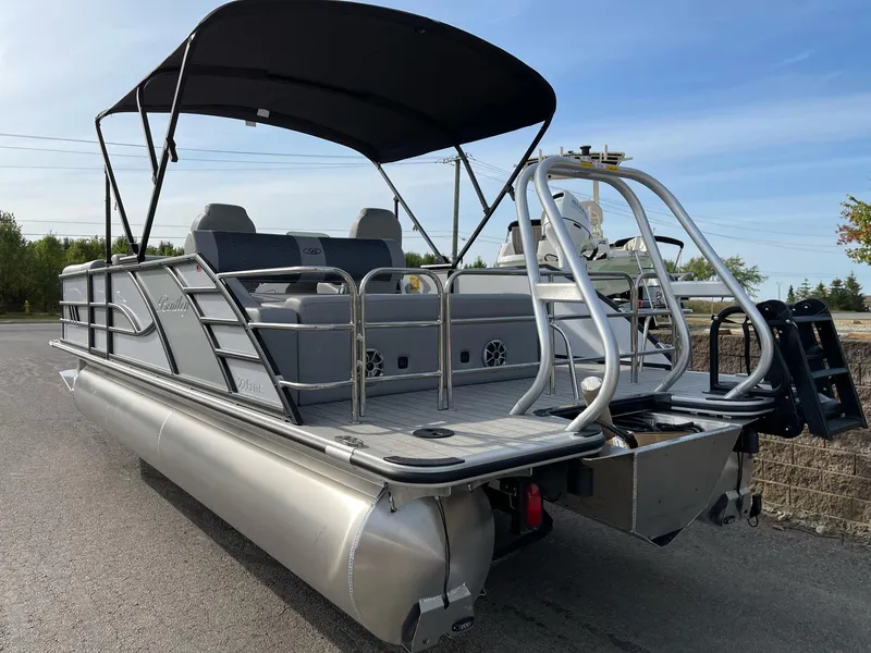 Slide: The Image of 2025 Bentley Pontoons Elite 223 Swingback with canopy, rear view on pavement. - 4