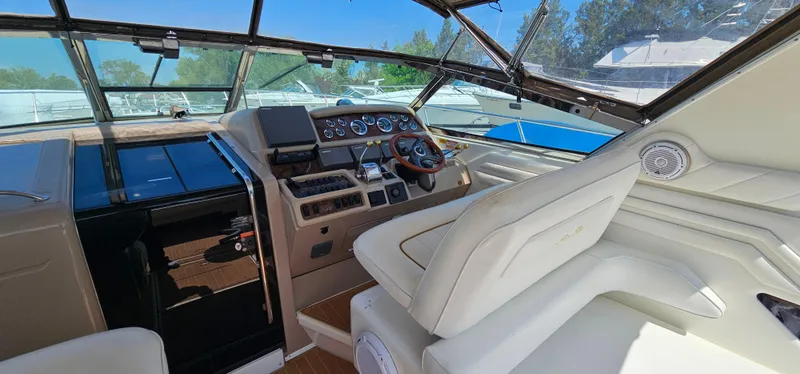 Slide: The Image of 1999 Sea Ray 400 Express Cruiser cockpit with steering wheel, gauges, and white seating. - 10