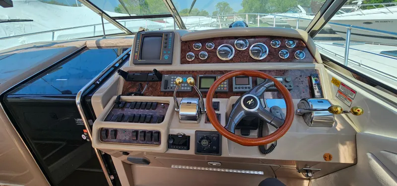 Slide: The Image of 1999 Sea Ray 400 Express Cruiser helm with wood accents and modern controls. - 17