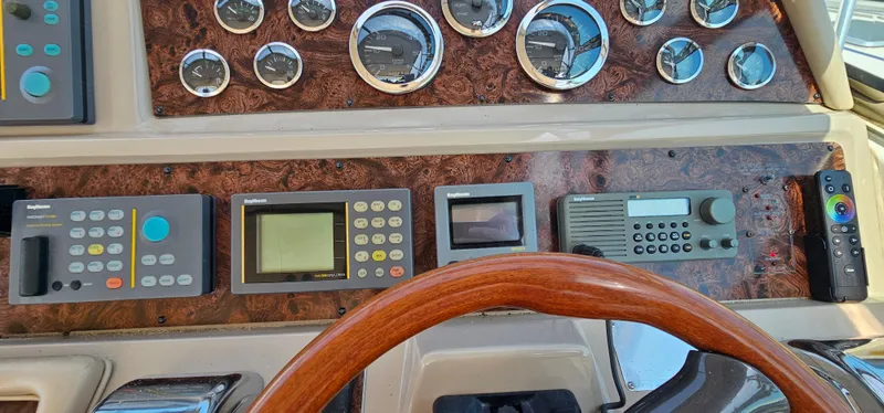 Slide: The Image of Dashboard of a 1999 Sea Ray 400 Express Cruiser with gauges and navigation controls. - 18