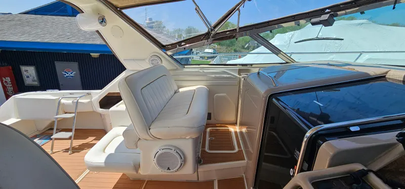 Slide: The Image of 1999 Sea Ray 400 Express Cruiser interior with white seating and wooden flooring. - 19