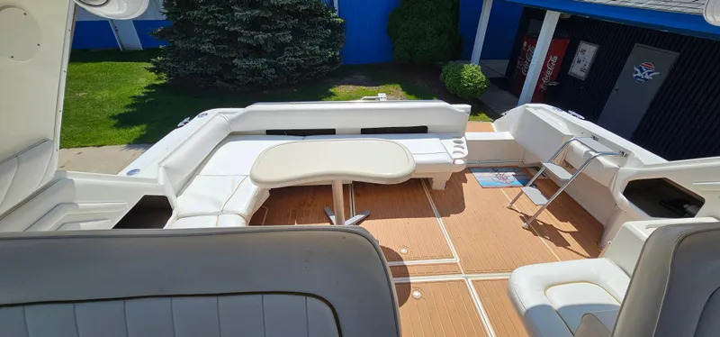 Slide: The Image of 1999 Sea Ray 400 Express Cruiser with spacious seating and table on deck. - 20
