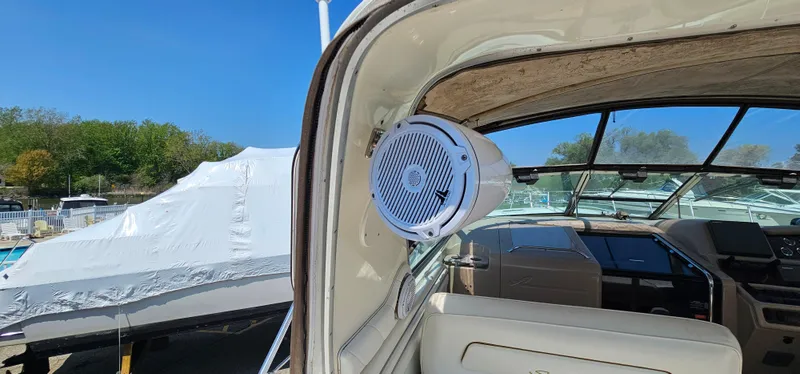 Slide: The Image of 1999 Sea Ray 400 Express Cruiser interior with speaker, docked under clear blue sky. - 21