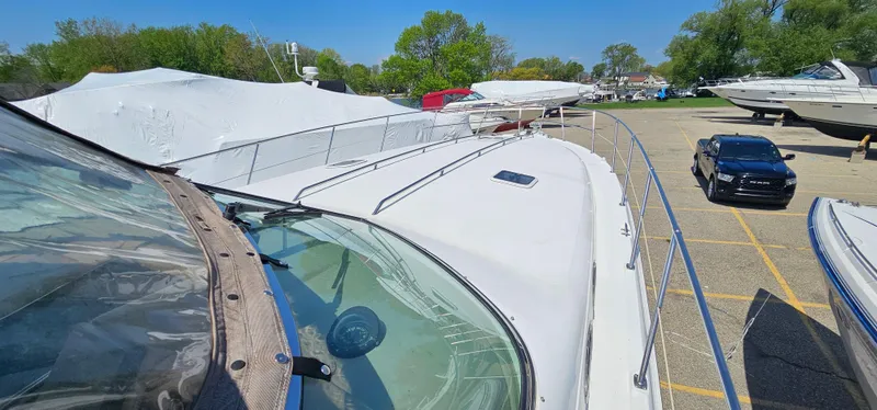Slide: The Image of 1999 Sea Ray 400 Express Cruiser docked, surrounded by other boats and vehicles. - 23