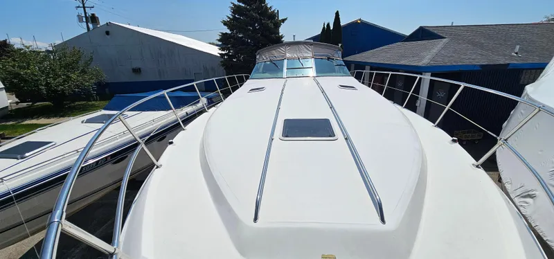 Slide: The Image of 1999 Sea Ray 400 Express Cruiser boat docked, showcasing sleek design and spacious deck. - 24