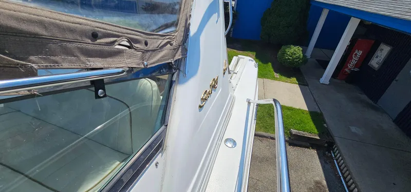 Slide: The Image of 1999 Sea Ray 400 Express Cruiser docked, showcasing sleek design and polished railings. - 25