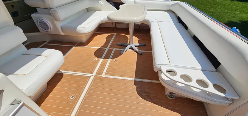 Slide: The Image of 1999 Sea Ray 400 Express Cruiser interior with white seating and wooden deck. - 26