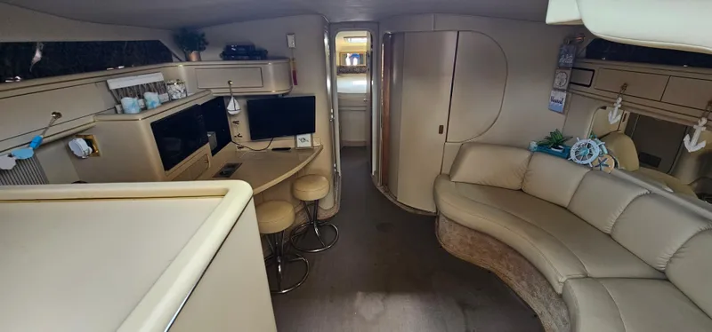 Slide: The Image of Interior of 1999 Sea Ray 400 Express Cruiser with seating, kitchenette, and TV. - 28