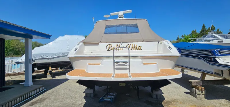 Slide: The Image of 1999 Sea Ray 400 Express Cruiser docked, rear view, with "Bella Vita" on the back. - 3