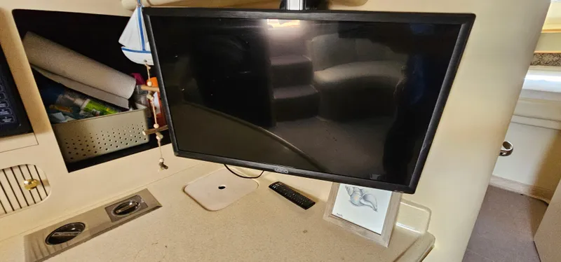 Slide: The Image of Interior of 1999 Sea Ray 400 Express Cruiser with mounted TV and storage compartments. - 33