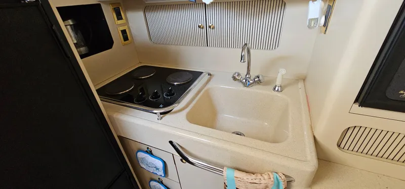 Slide: The Image of 1999 Sea Ray 400 Express Cruiser kitchen with stove, sink, and storage. - 36