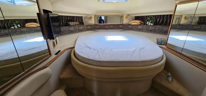 Slide: The Image of 1999 Sea Ray 400 Express Cruiser cabin interior with bed, mirrors, and skylight. - 37