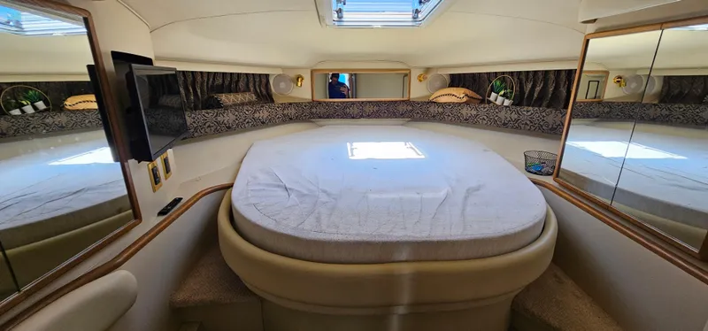 Slide: The Image of 1999 Sea Ray 400 Express Cruiser cabin with bed, skylight, and TV. - 39
