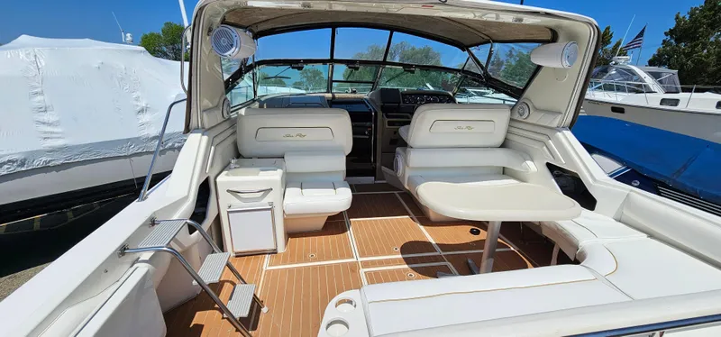 Slide: The Image of 1999 Sea Ray 400 Express Cruiser interior with white seating and wooden flooring. - 5