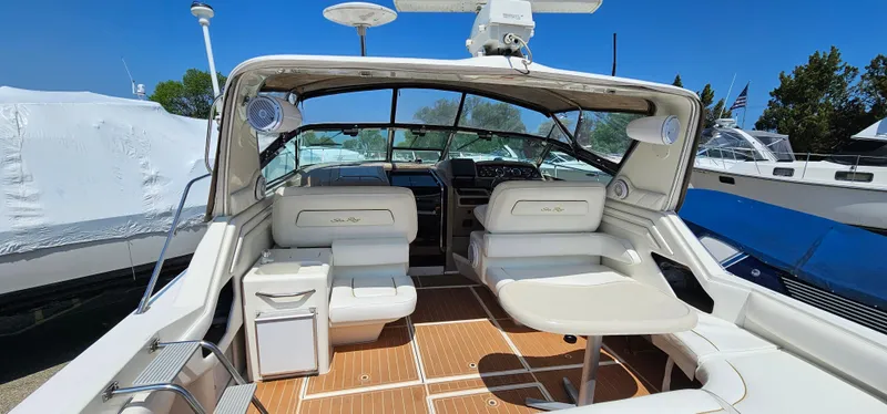Slide: The Image of 1999 Sea Ray 400 Express Cruiser interior with seating and table, showcasing luxury boat design. - 6