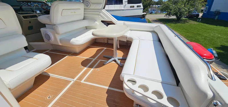 Slide: The Image of 1999 Sea Ray 400 Express Cruiser interior with white seating and wooden flooring. - 7