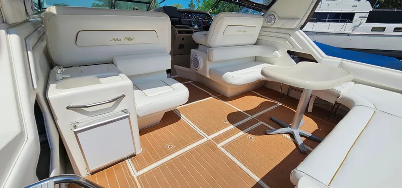 Slide: The Image of 1999 Sea Ray 400 Express Cruiser interior with white seating and wood flooring. - 8