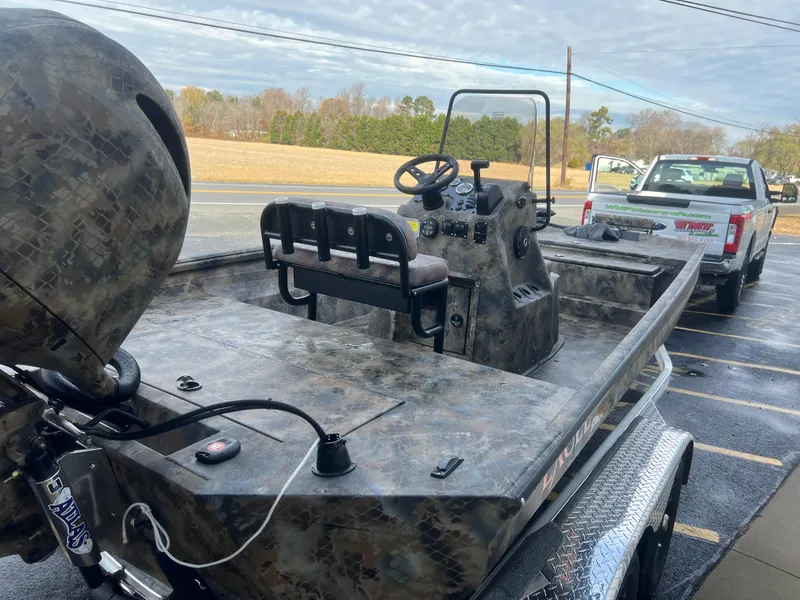 Slide: The Image of Excel 2072 Stalker SC 2025 boat with camouflage design, parked on a trailer. - 10