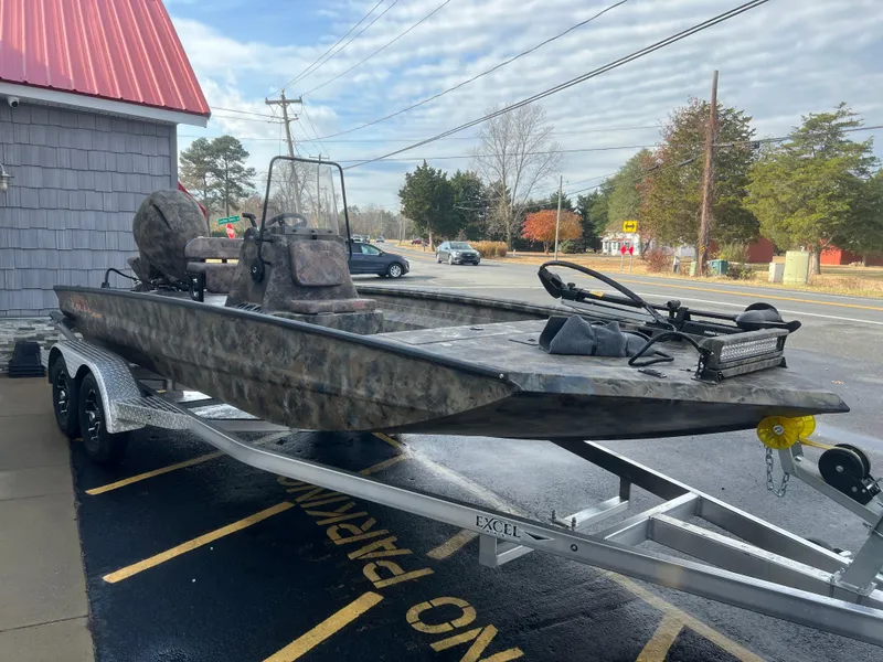 Slide: The Image of 2025 Excel 2072 Stalker SC boat on trailer, parked outdoors. - 2