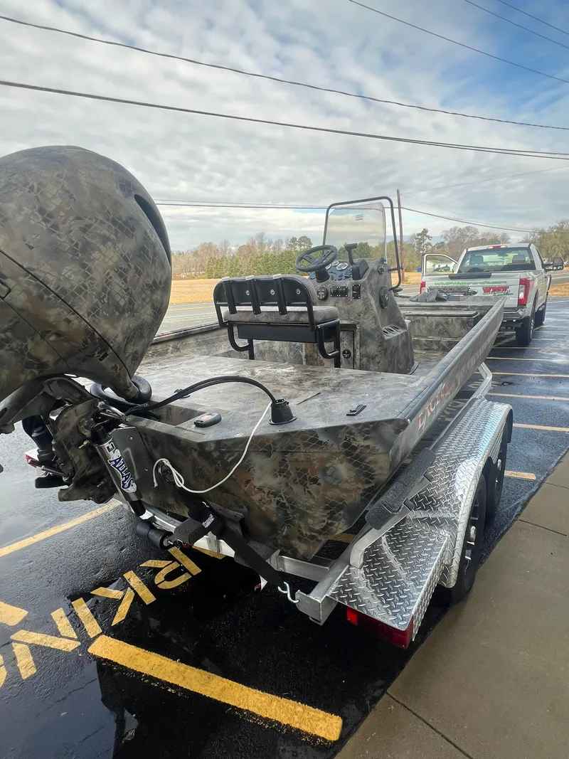 Slide: The Image of 2025 Excel 2072 Stalker SC boat on trailer, camo design, parked outdoors. - 8