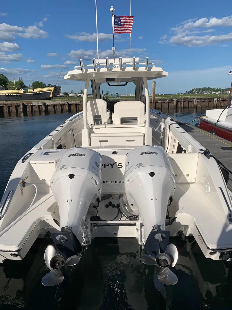 Slide: The Image of 2021 Pursuit S 328 Sport boat docked with twin engines and American flag. - 3