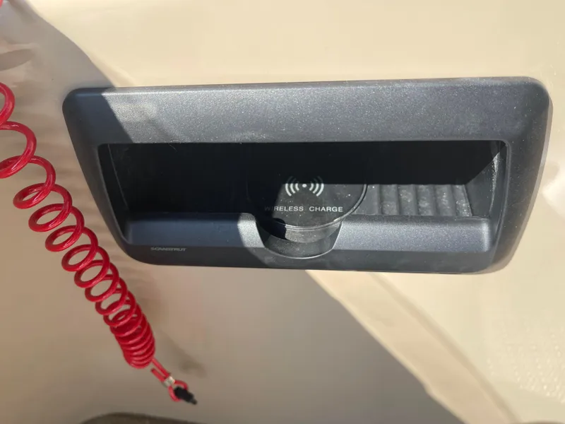 Slide: The Image of 2024 Bentley Pontoons Legacy 200 Navigator wireless charging station with red coiled cable. - 20