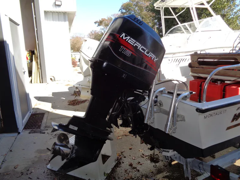 Slide: The Image of 1980 Boston Whaler 17 Montauk with Mercury 115 outboard motor in a boatyard. - 11