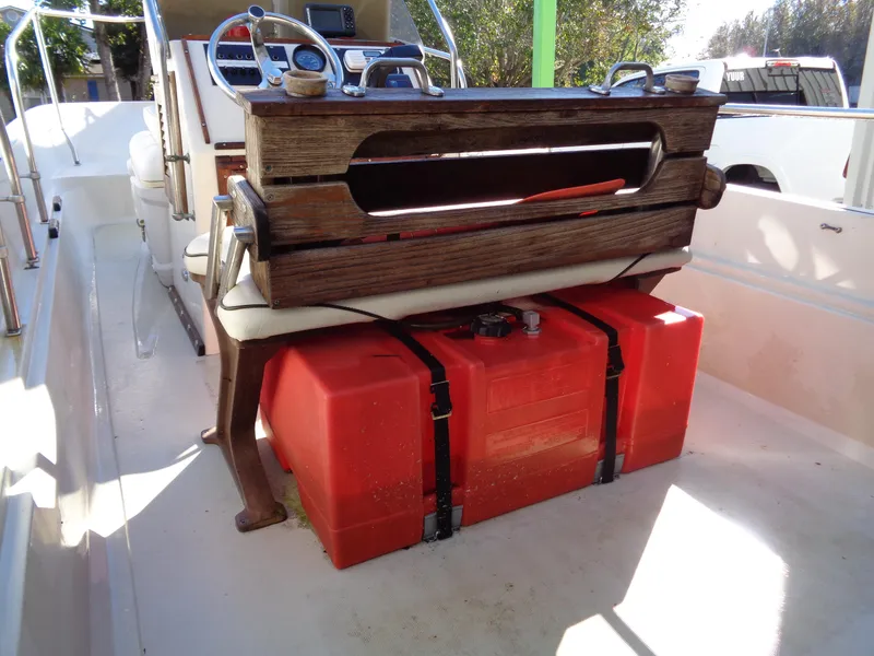 Slide: The Image of 1980 Boston Whaler 17 Montauk interior with red fuel tank and wooden console. - 13