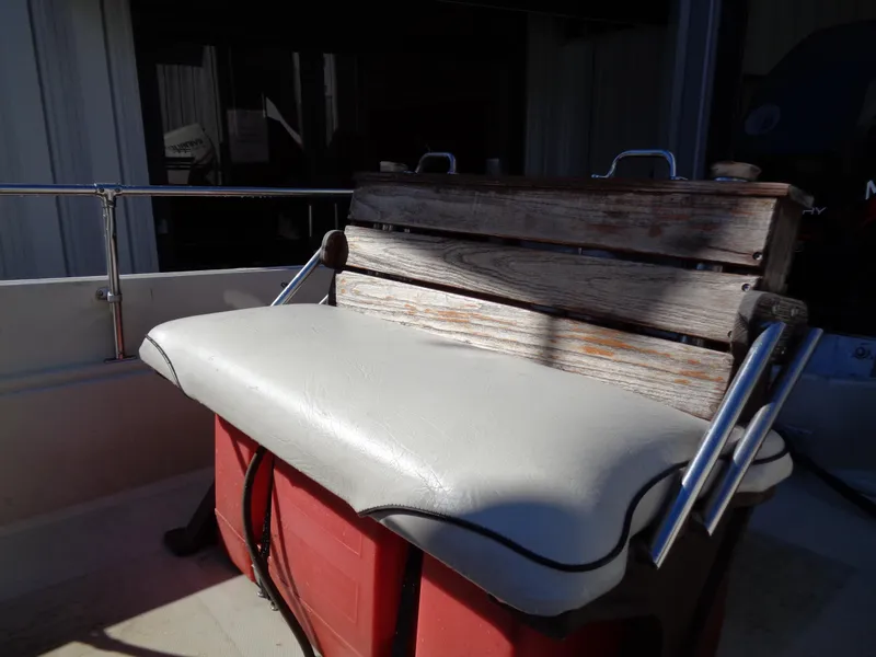 Slide: The Image of 1980 Boston Whaler 17 Montauk boat seat with wooden backrest and white cushion. - 15