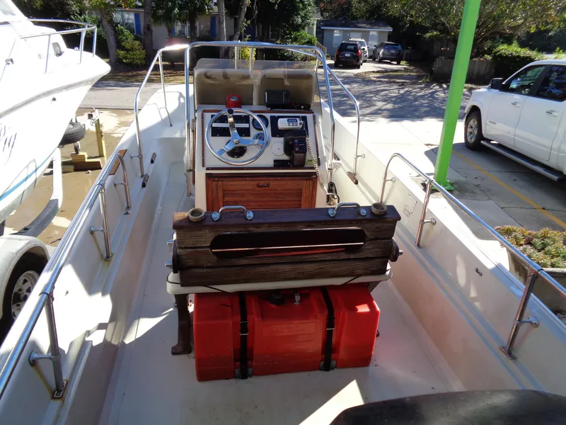 Slide: The Image of 1980 Boston Whaler 17 Montauk boat interior with steering console and red fuel tanks. - 4
