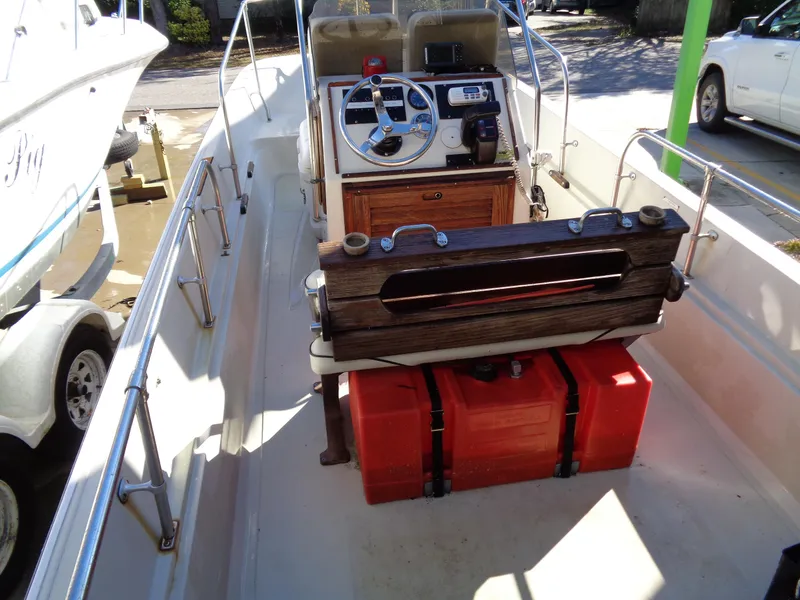 Slide: The Image of 1980 Boston Whaler 17 Montauk boat interior with steering console and red fuel tanks. - 6