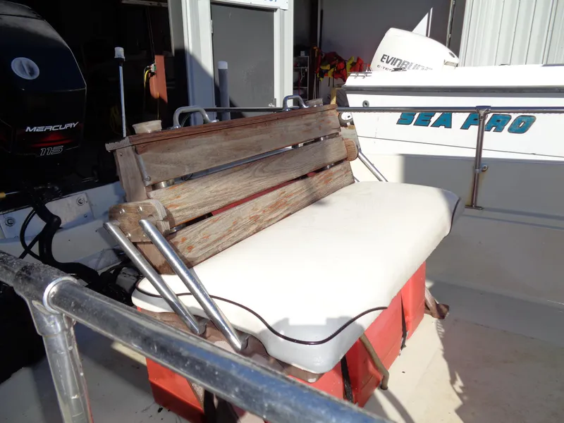 Slide: The Image of 1980 Boston Whaler 17 Montauk boat interior with wooden bench and Mercury engine. - 7