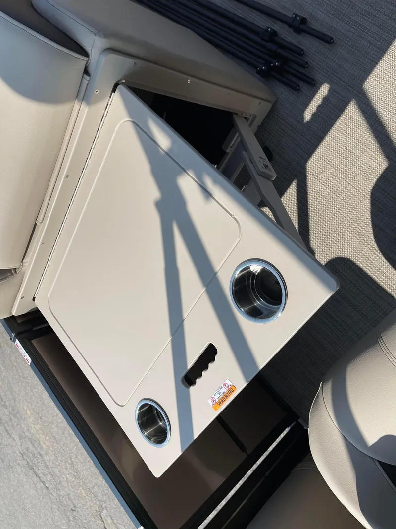 Slide: The Image of 2024 Bentley Pontoons Legacy 200 Navigator interior with cup holders and storage compartment. - 11