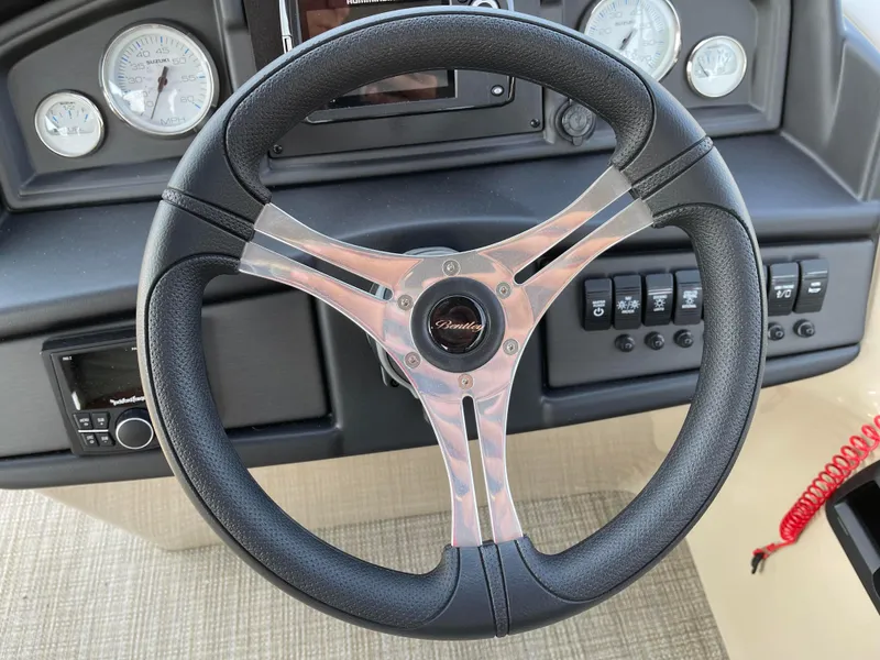 Slide: The Image of 2024 Bentley Pontoons Legacy 200 Navigator steering wheel and dashboard controls. - 17