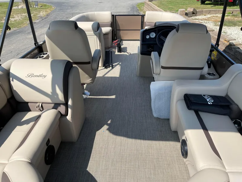 Slide: The Image of 2024 Bentley Pontoons Legacy 200 Navigator interior with beige seating and steering console. - 24
