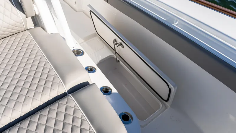 Slide: The Image of 2025 Valhalla Boatworks V-37 interior seating with storage compartment and cup holders. - 36