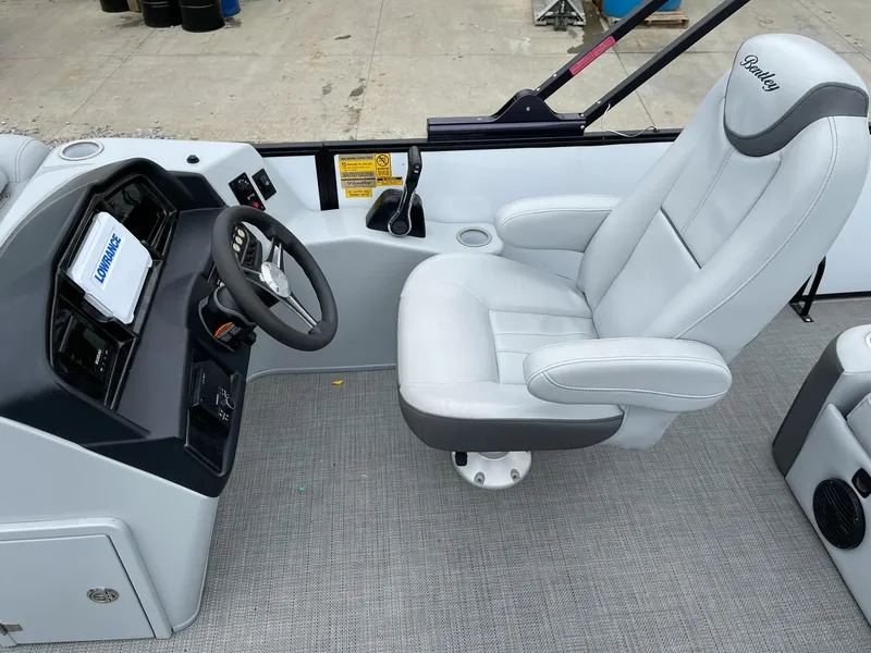 Slide: The Image of 2022 Bentley Pontoons Elite 223 Swingback interior with captain's chair and control panel. - 14