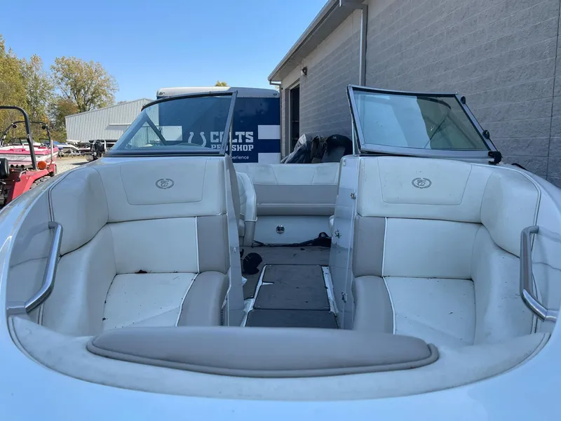 Slide: The Image of 1996 Cobalt 190 Bowrider boat with white interior, parked near a building. - 5