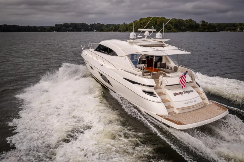 Slide: The Image of 2017 Riviera 6000 Sport Yacht cruising on a lake under cloudy skies. - 10