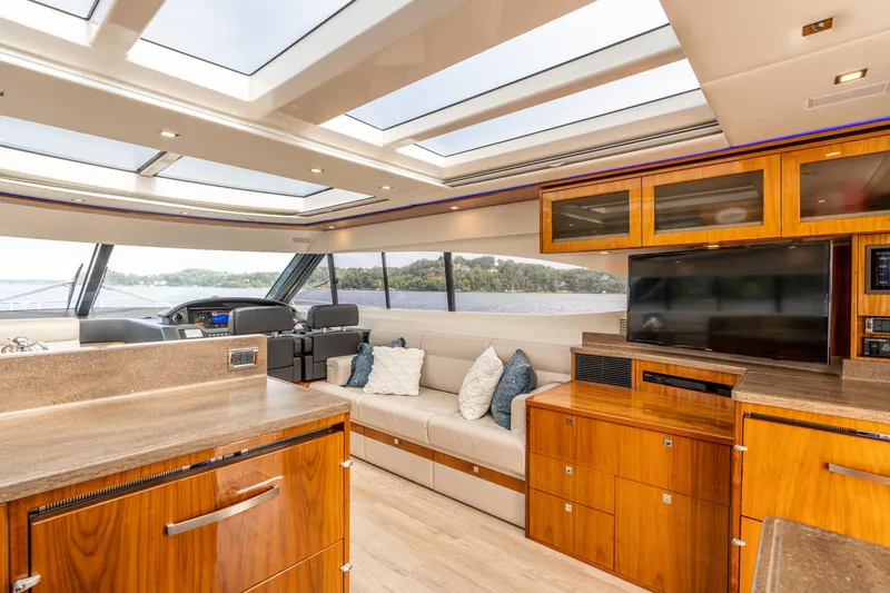 Slide: The Image of Luxurious interior of 2017 Riviera 6000 Sport Yacht with modern furnishings and panoramic windows. - 16