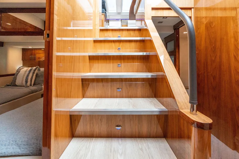 Slide: The Image of Interior staircase of 2017 Riviera 6000 Sport Yacht, featuring elegant wood finish and modern design. - 31