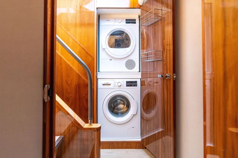 Slide: The Image of Laundry area with stacked washer and dryer in 2017 Riviera 6000 Sport Yacht. - 34