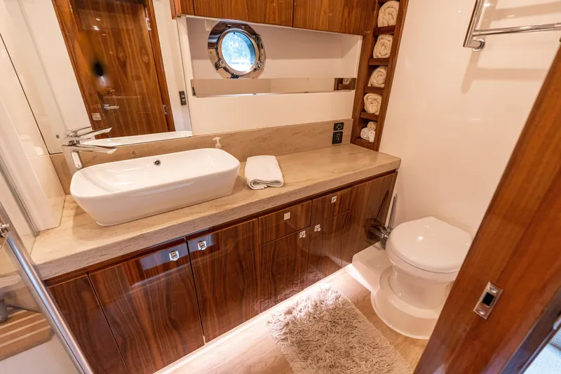 Slide: The Image of Luxurious bathroom in 2017 Riviera 6000 Sport Yacht with modern sink and wooden cabinetry. - 44