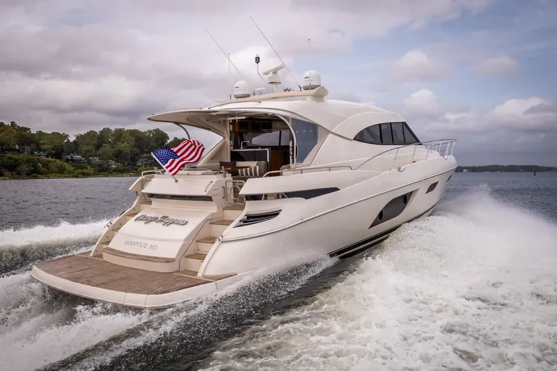 Slide: The Image of 2017 Riviera 6000 Sport Yacht cruising on water with American flag. - 8