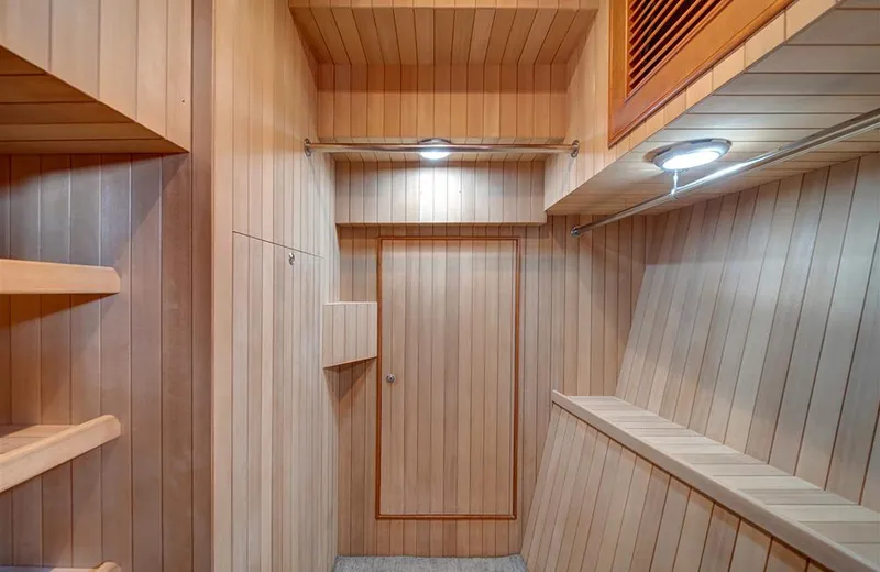 Slide: The Image of Interior of 2020 Outer Reef Yachts 720 Deluxbridge Motoryacht, featuring wooden paneling and shelving. - 25
