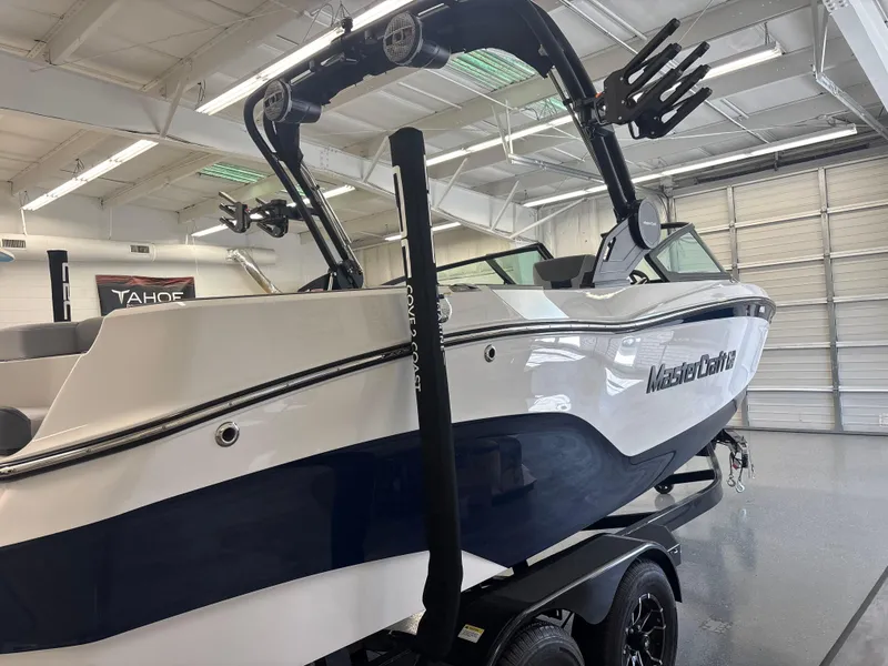 Slide: The Image of 2025 MasterCraft XT22 boat in showroom, featuring sleek design and modern features. - 13