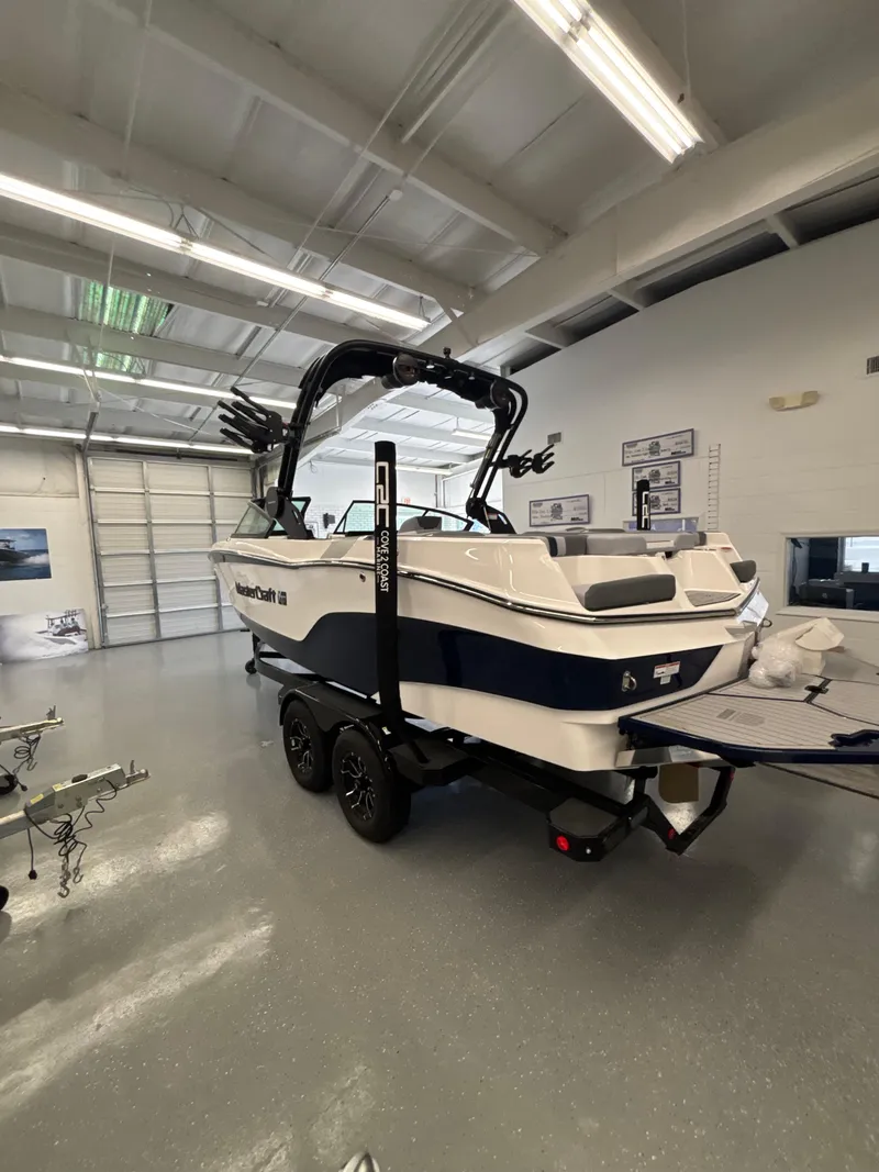 Slide: The Image of 2025 MasterCraft XT22 boat in showroom, featuring sleek design and modern features. - 14