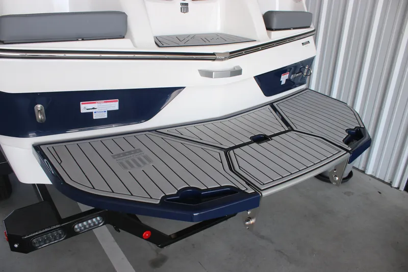 Slide: The Image of 2025 MasterCraft XT22 boat with sleek swim platform in a storage facility. - 6
